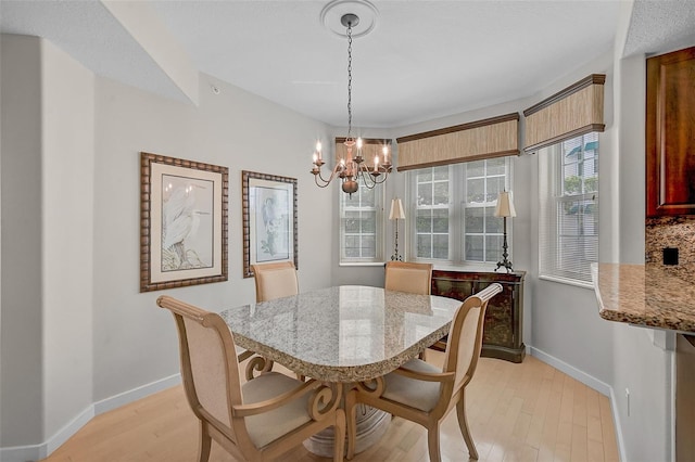 dining area with an inviting chandelier, plenty of natural light, and light hardwood / wood-style floors