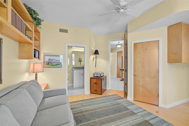 unfurnished living room featuring a textured ceiling, ceiling fan, and light hardwood / wood-style flooring