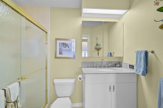 bathroom with walk in shower, vanity, and toilet