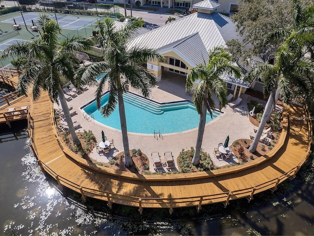 view of pool with a patio and a water view