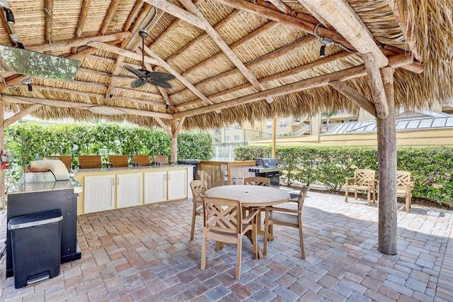 view of patio featuring exterior kitchen, area for grilling, ceiling fan, and a gazebo