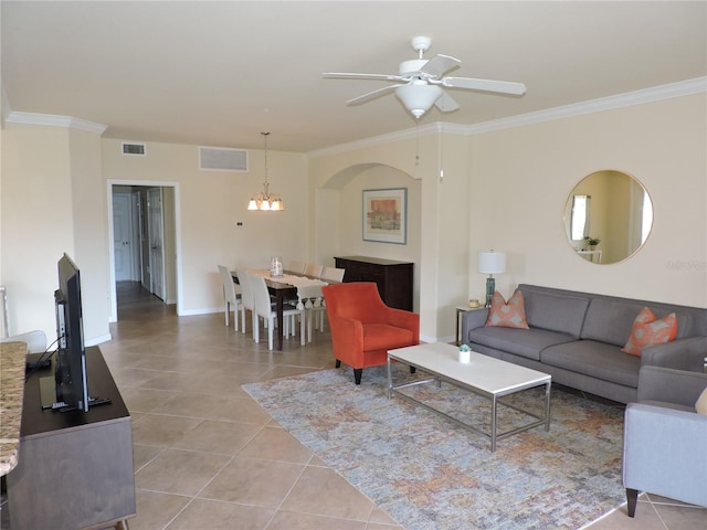 tiled living room featuring ceiling fan with notable chandelier and ornamental molding