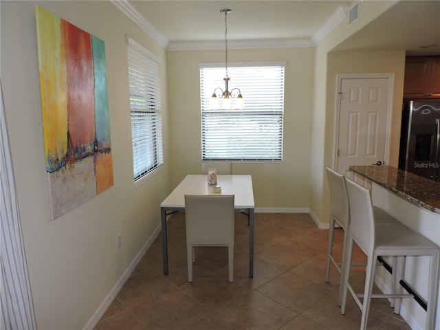 dining space with light tile patterned floors, crown molding, and a chandelier