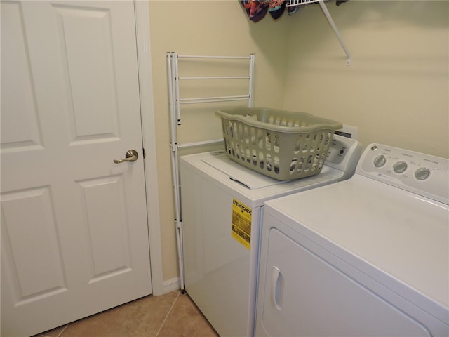 laundry room featuring light tile patterned floors and washer and clothes dryer