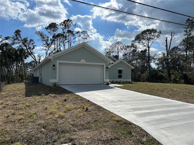 view of front of home with a garage, central AC unit, and a front lawn