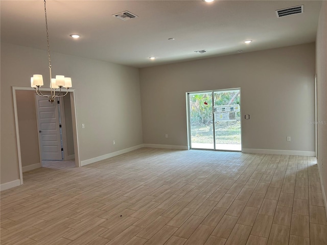 unfurnished room featuring light hardwood / wood-style floors and a notable chandelier