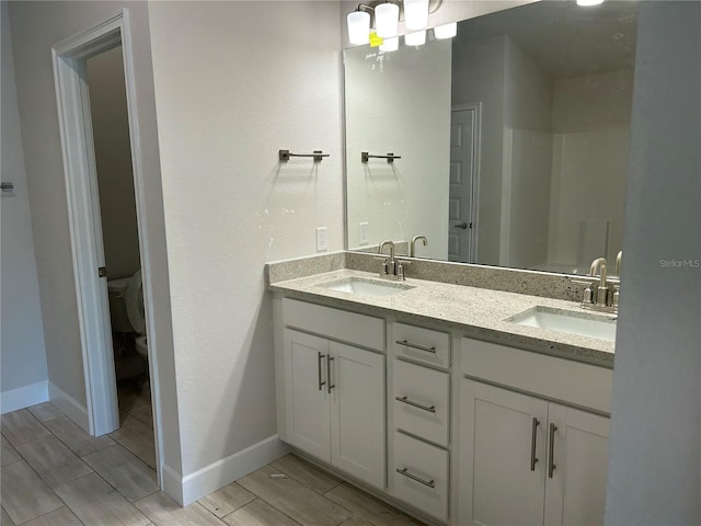 bathroom with vanity, toilet, and a shower