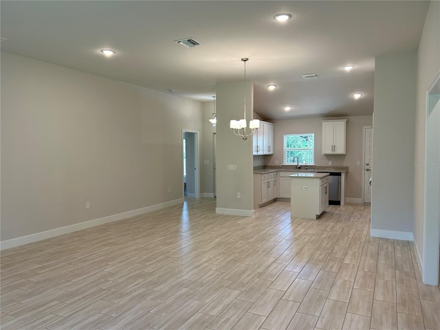 5661 Gaffney Rd, North Port, FL 34286 - kitchen with open floor plan, light wood-type flooring, a chandelier, a kitchen island, and decorative light fixtures