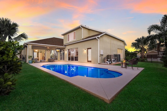 pool at dusk with a patio, central AC, and a lawn