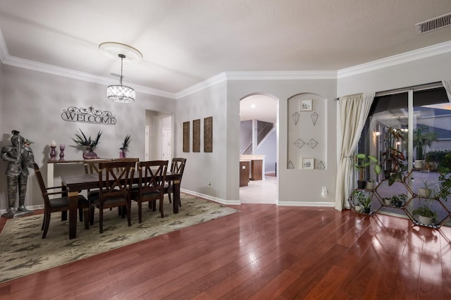 dining room with crown molding, a textured ceiling, a notable chandelier, and wood-type flooring