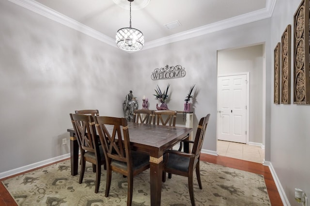 dining area featuring a chandelier, crown molding, and light hardwood / wood-style floors