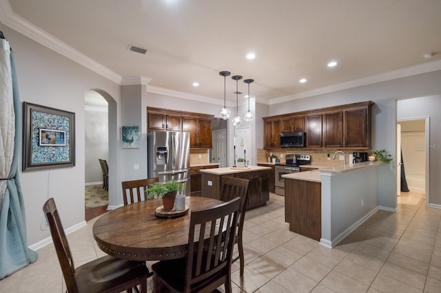 dining area featuring sink, crown molding, a notable chandelier, and light tile patterned floors