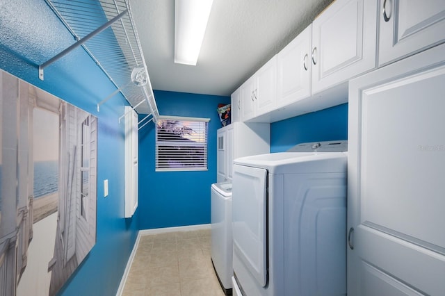 washroom featuring light tile patterned flooring, cabinets, and washer and clothes dryer