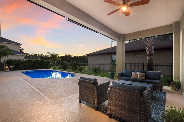 pool at dusk featuring a patio, an outdoor hangout area, and ceiling fan