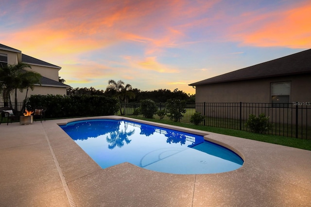 pool at dusk featuring a patio area