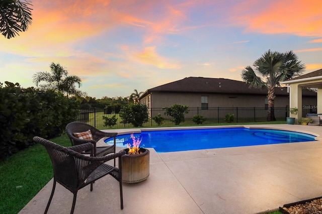 pool at dusk featuring a patio area