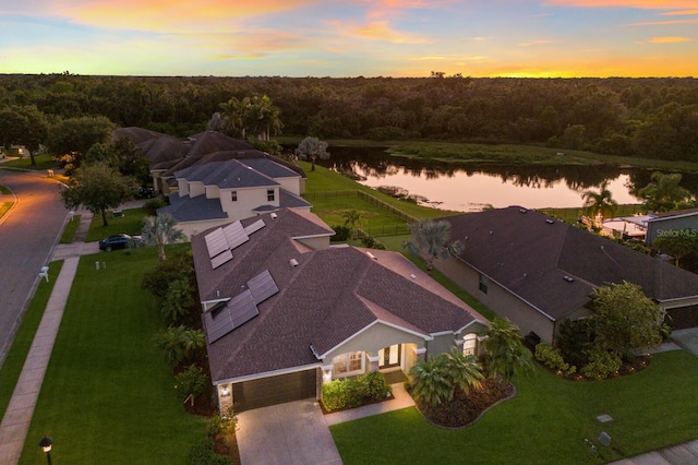 aerial view at dusk featuring a water view