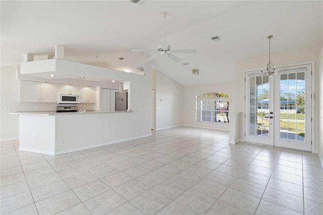 unfurnished living room featuring ceiling fan with notable chandelier, lofted ceiling, light tile patterned floors, and french doors