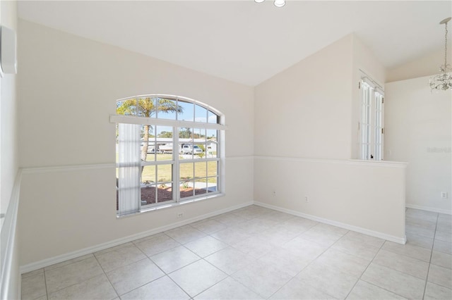 spare room with a notable chandelier, lofted ceiling, and light tile patterned floors