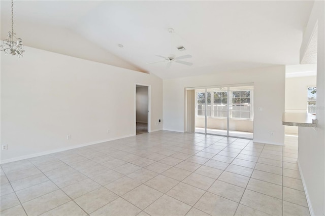 tiled spare room with ceiling fan with notable chandelier and lofted ceiling