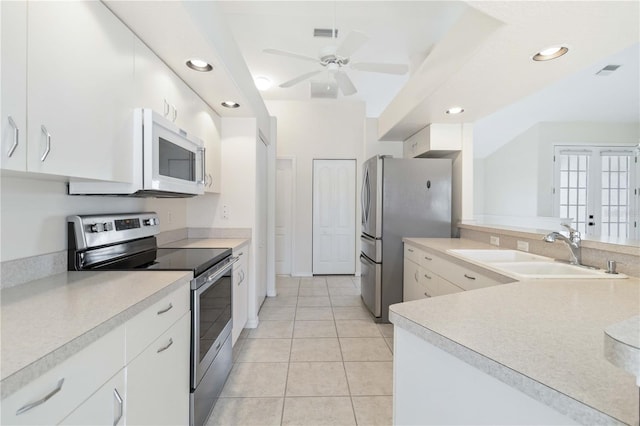 kitchen featuring french doors, white cabinets, sink, light tile patterned floors, and appliances with stainless steel finishes