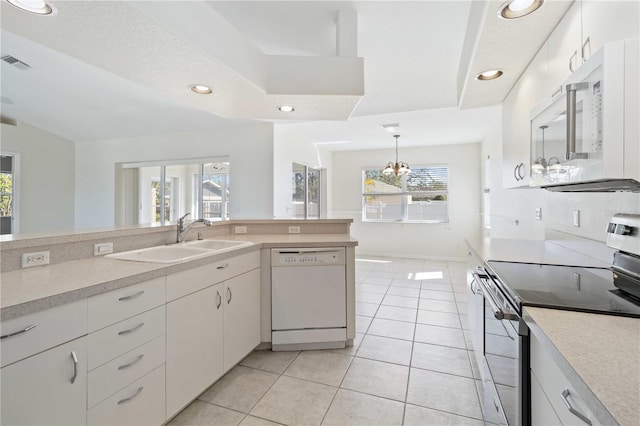 kitchen featuring white cabinetry, sink, a healthy amount of sunlight, and white appliances