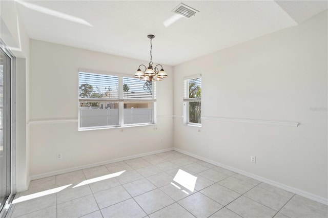 spare room with light tile patterned floors and a notable chandelier