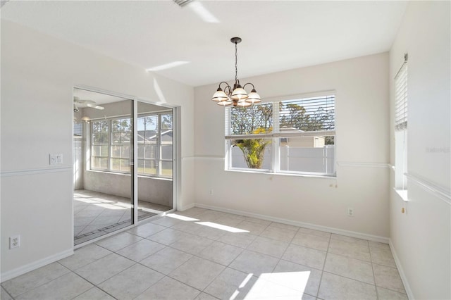 unfurnished dining area featuring light tile patterned floors, a healthy amount of sunlight, and ceiling fan with notable chandelier