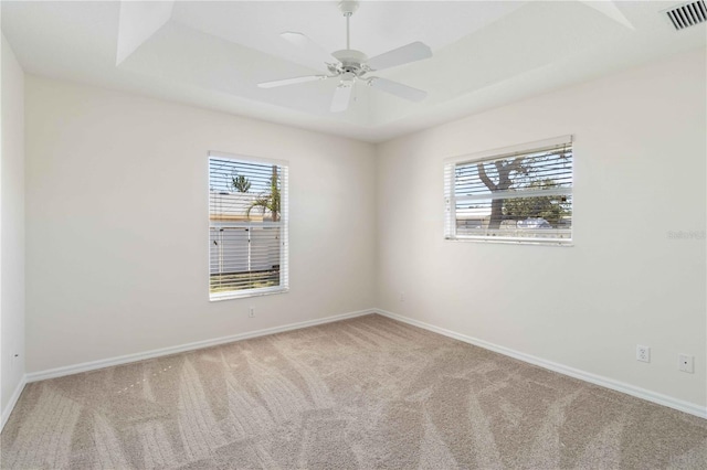 unfurnished room with light colored carpet, ceiling fan, and a healthy amount of sunlight