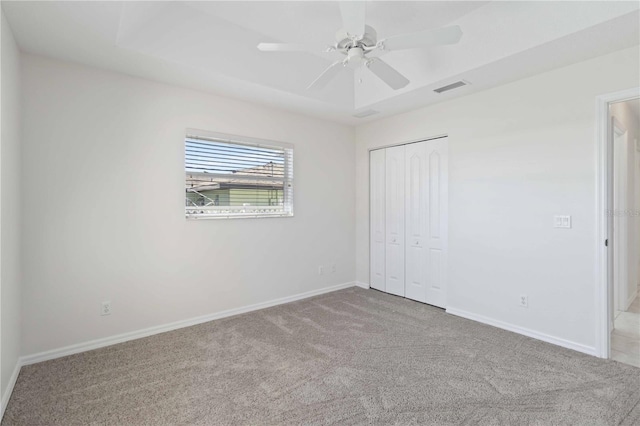 unfurnished bedroom with ceiling fan, light carpet, and a closet