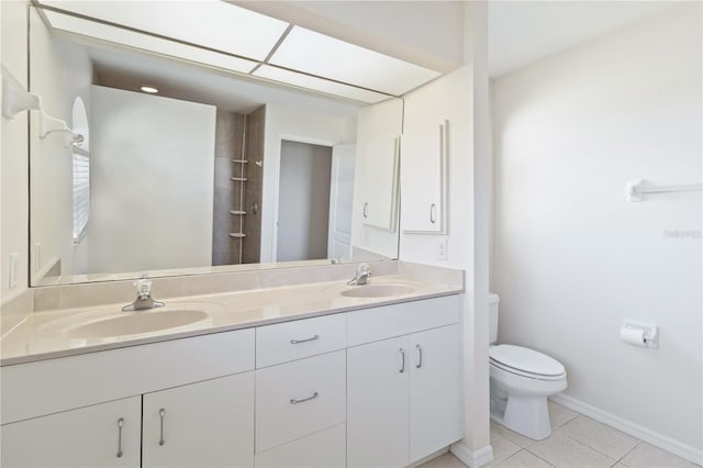 bathroom with tile patterned floors, vanity, toilet, and a shower