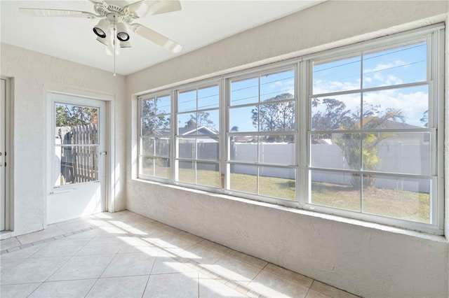 unfurnished sunroom with ceiling fan