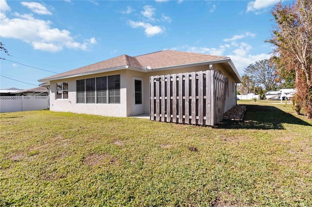 back of property featuring a lawn