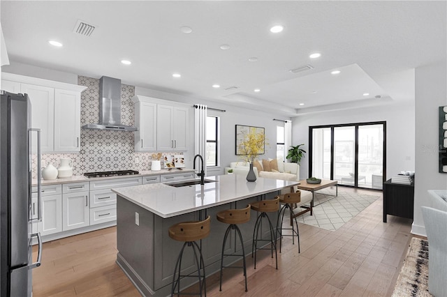 18824 Dayspring Pl, Venice, FL 34293 - kitchen featuring wall chimney exhaust hood, a sink, open floor plan, stainless steel appliances, and a kitchen island with sink