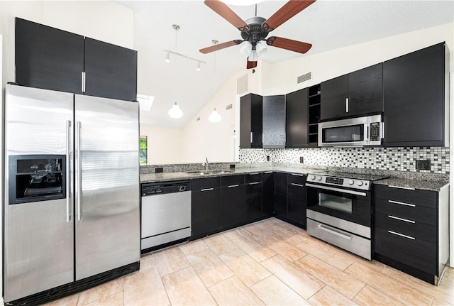 kitchen with sink, vaulted ceiling, decorative backsplash, appliances with stainless steel finishes, and ceiling fan