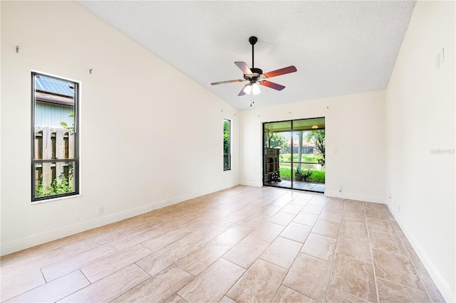 empty room featuring lofted ceiling, ceiling fan, and a textured ceiling