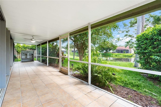 unfurnished sunroom featuring a water view and ceiling fan