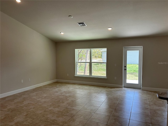 unfurnished room with light tile patterned floors and a wealth of natural light