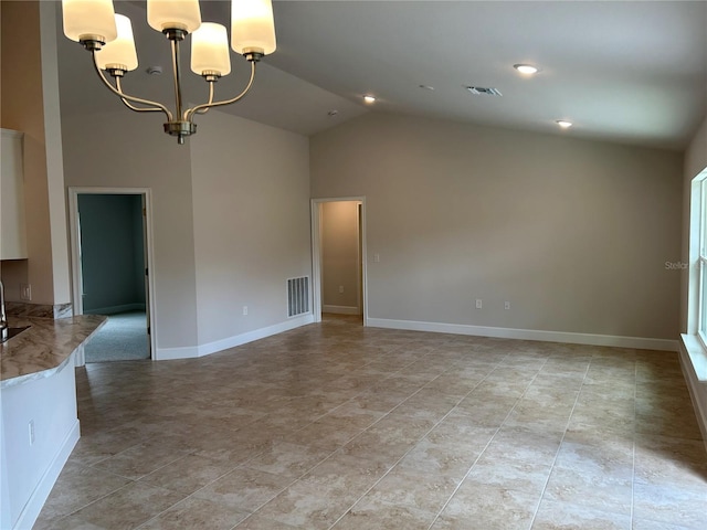 spare room with an inviting chandelier and high vaulted ceiling