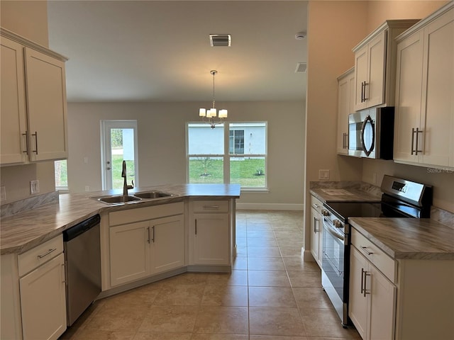 kitchen with pendant lighting, sink, a chandelier, kitchen peninsula, and stainless steel appliances