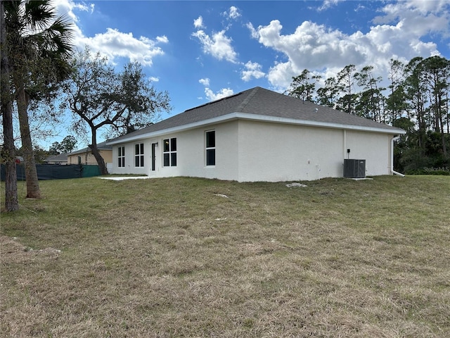 back of property with cooling unit and a lawn