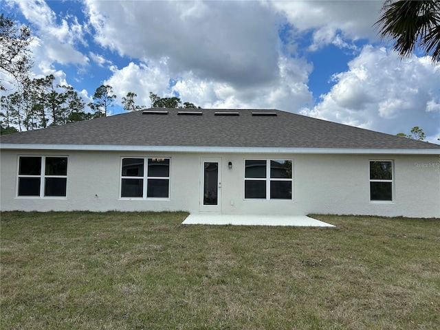 back of property featuring a lawn and a patio