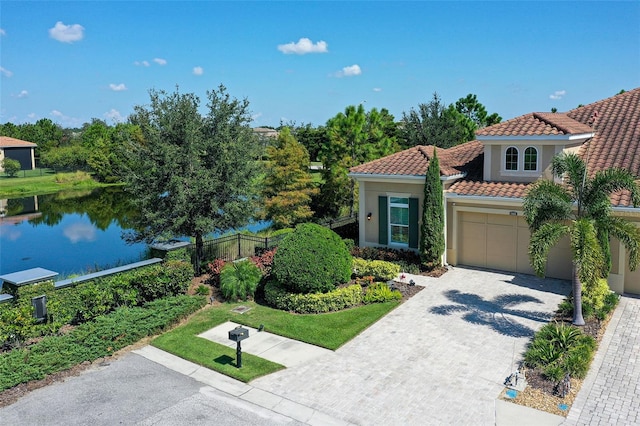 mediterranean / spanish home with a garage and a water view