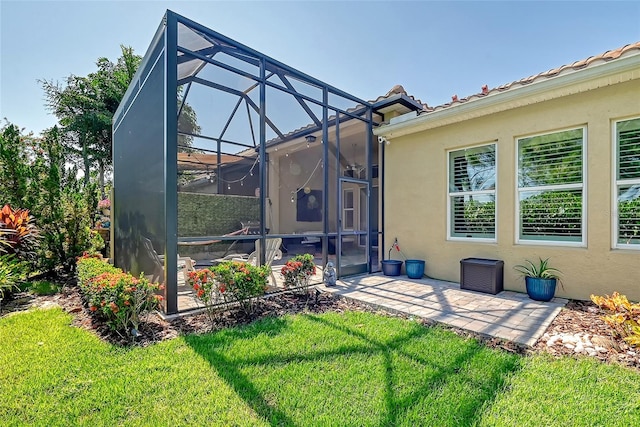 rear view of property featuring a lanai, a yard, and a patio area