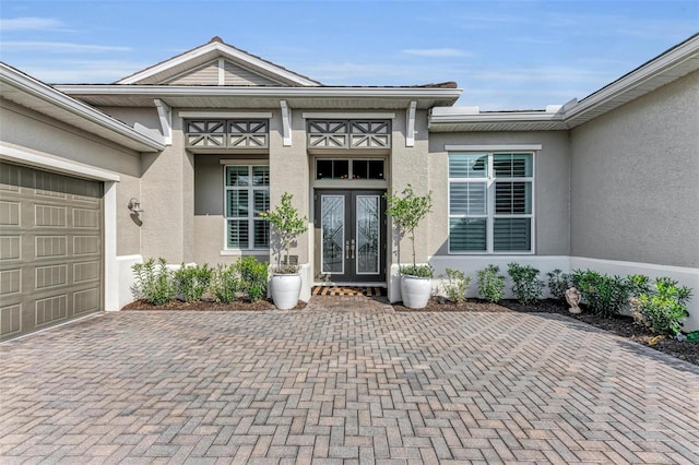 view of exterior entry with french doors and a garage