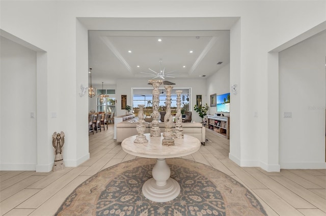 foyer with ceiling fan and a tray ceiling