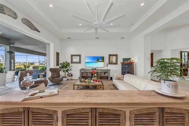 living room with ceiling fan and a tray ceiling