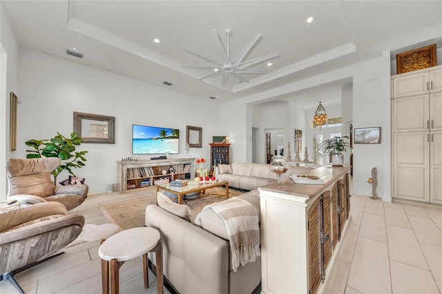 living room with ceiling fan, ornamental molding, and a raised ceiling