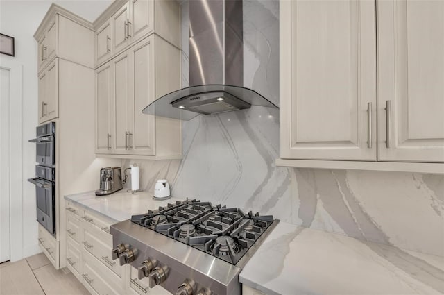 kitchen featuring ventilation hood, stainless steel appliances, decorative backsplash, and light stone countertops