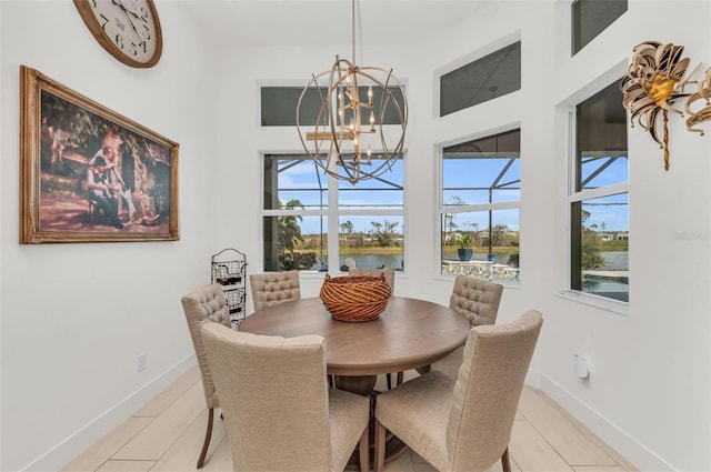 dining space featuring a water view and an inviting chandelier